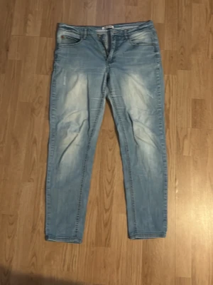 Ljusblå jeans från Hampton Republic - Säljer ett par ljusblå jeans från Hampton Republic med klassisk femficksmodell och snygga slitningar. Jeansen har normal midja och raka ben, tillverkade i mjukt denimtyg. Perfekta för en avslappnad och trendig look.