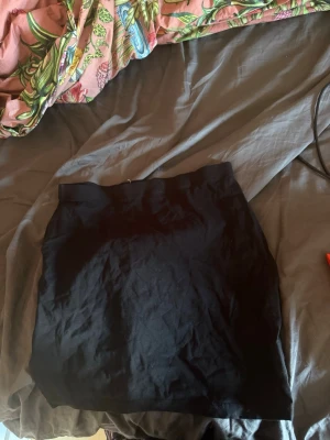 Svart kortkjol i bomull - En enkel svart kortkjol i mjukt bomullsmaterial. Kjolen har en rak passform