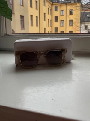 Beige fyrkantiga solglasögon från chimi 04  - Snygga solglasögon med transparent beige båge och fyrkantig form. Glasen är mörka och ger en cool kontrast till den ljusa bågen. Perfekta för dig som vill ha en trendig accessoar till sommaren. 04
