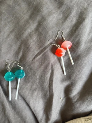 Örhängen med klubba - Unika örhängen formade som klubbor, ett par i turkos och ett par i rött och rosa. Snygg och lekfull design med metallkrok. Perfekt för dig som vill sticka ut med färgglada accessoarer.