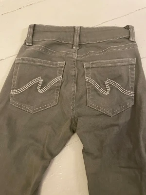 Olivgröna nelly jeans - Low waist bootcut stitch jeans från Nelly i storlek 32. Olivgröna. Jättefina och i mycket bra skick, har sytt upp de lite, så innerbenslängd 70 cm💓