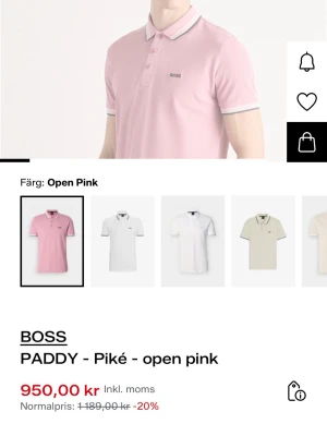 Rosa pikétröja från BOSS - Snygg rosa pikétröja från BOSS med klassisk krage och knappar framtill. Tröjan har vita och grå detaljer på krage och ärmslut samt diskret BOSS-logga på bröstet. Perfekt för en stilren och avslappnad look.