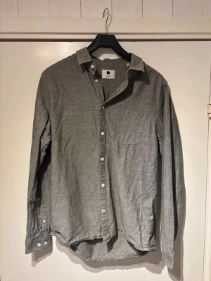 Grå långärmad skjorta från NN07 - Stilren grå skjorta från NN07 i mjukt bomullstyg. Helt oanvänd. Hör av vid frågor.