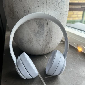 Beats solo 3 by Dr Dre - Snygga vita trådlösa on-ear hörlurar från Beats by Dr Dre. De har vadderade öronkuddar som är utbytta och oanvända. Justerbart huvudband. Enkel hopfällbar funktion för smidig förvaring. Säljer enbart hörlurarna eller som en deal med mina andra beats studio 3.