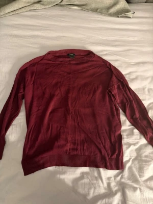 Vinröd stickad tröja från Lindex - Säljer en vinröd stickad tröja från Lindex i storlek S. Tröjan har rund halsringning, långa ärmar och ribbstickade muddar vid ärmslut och nederkant. Perfekt för lager-på-lager och enkel att matcha med jeans eller kjol.