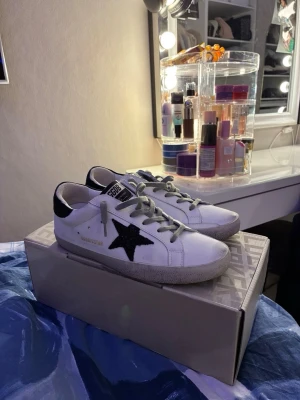 Golden Goose vita sneakers med svart stjärna - Tjena, så att syrran valt att sälja ett par skor som hon inte Använder. Dom har varit använda ett  par gånger. Allt med skorna till kommer alltså dustbag och kvitto kom dm för mer info.😁