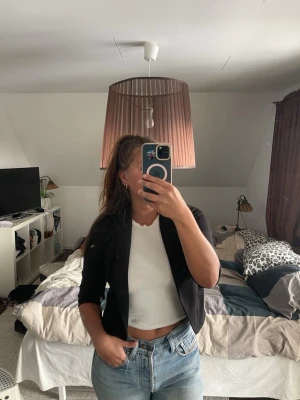 Svart kort kavaj med trekvartsärm - Snygg svart kavaj med öppen front och trekvartsärmar. Materialet är stretchigt och bekvämt.