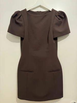 Brun klänning från Zara  - Snygg brun kortklänning med puffiga korta ärmar och figurnära passform. 