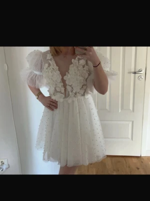 Vit klänning, studentklänning - Superfin vit kortklänning med djup v-ringning och puffärmar! Klänningen är öppen i ryggen. Perfekt som studentklänning ⭐️Endast använd på studentdagen! Nypris 1300 🤩