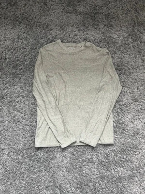 Ljusgrå långärmad tröja Jack & Jones - En stilren ljusgrå långärmad tröja från Jack & Jones. Tröjan är i storlek S och säljs för 120kr!