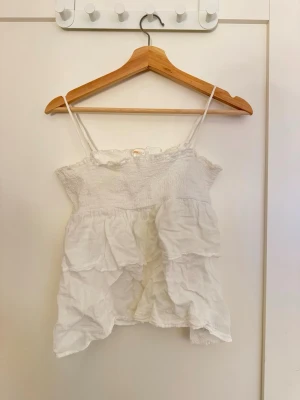 Vit volangtop från Gina Tricot - vit topp i volang från gina young. bra skick och knappast använd!❣️
