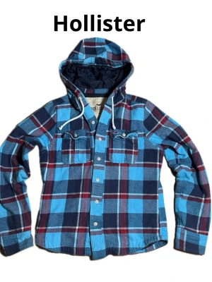 Blå Rutig Hollister Vintage Hoodie  - Säljer nu denna otroligt snygga vintage Hollister Hoodien med rutigt mönster. Tröjan är i skick 8/10. Hoodien är i storlek M och modellen på bilden är 183 och väger 67 kilo. Tröjan har inga defekter.  Priset är inte hugget i sten. Skriv gärna om ni har mer funderingar 😊/Filip
