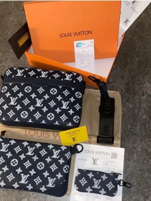 Louis Vuitton svart monogram handväska - Snygg svart handväska från Louis Vuitton med klassiskt vitt monogrammönster. Väskan har en avtagbar axelrem, dragkedja och flera fack. Tillverkad i canvas med detaljer i svart. Perfekt för dig som vill ha en trendig och exklusiv accessoar. Kan tänka mig gå ner i pris bara vid snabb affär 