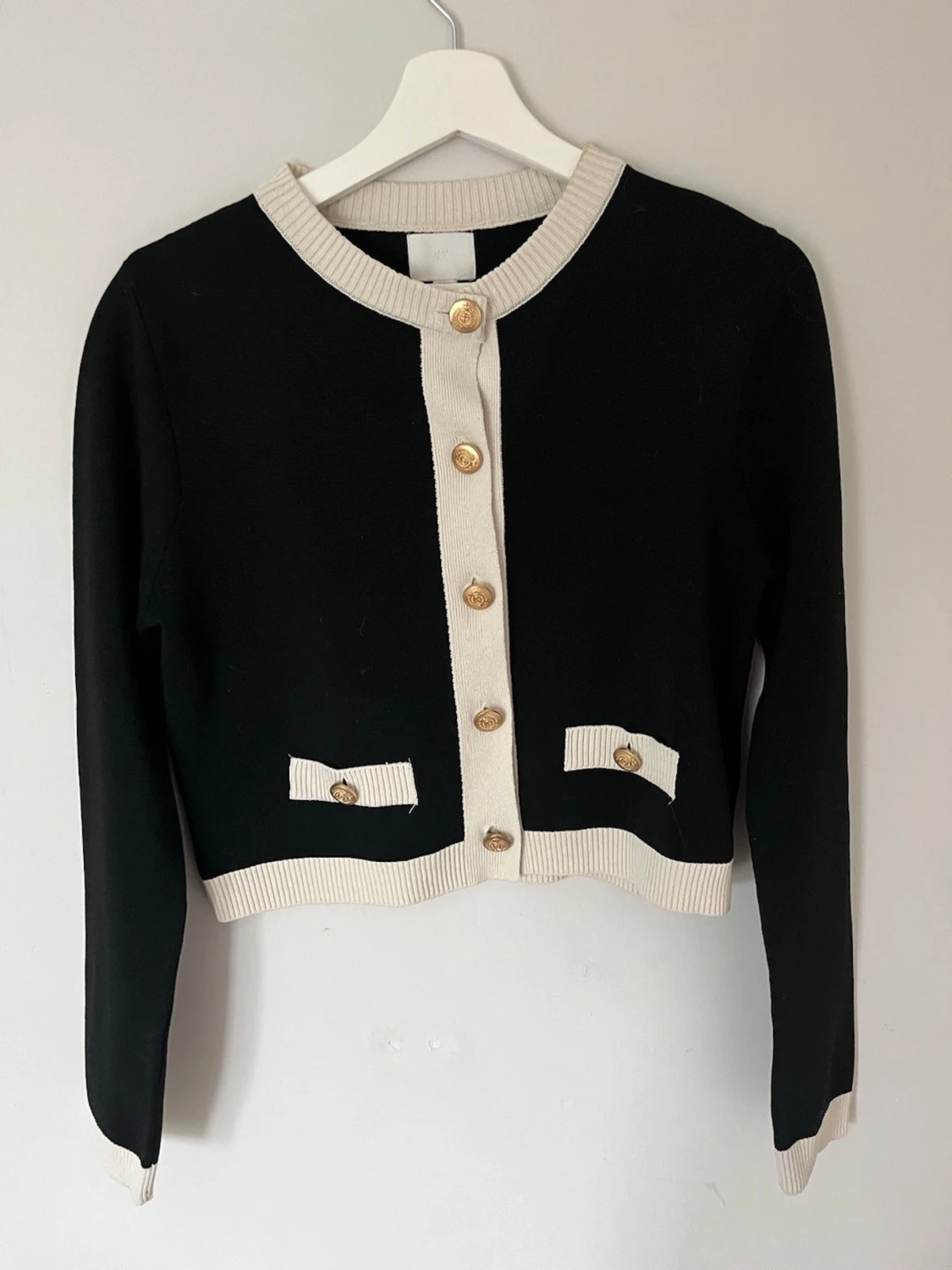 Svart och vit kofta med guldknappar