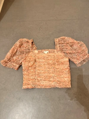 Topp med puffärmar - Superfin och gullig topp med puffärmar och blommigt mönster. Endast provad! 