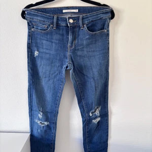 Levi’s jeans  - Snygga blå lågmidjade skinny jeans från Levi's med slitningar på benen. Säljer pga för små!