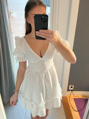 Vit klänning med puffärmar - Säljer en vit klänning med v-ringning och puffiga kortärmar. 