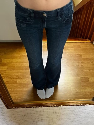 Marinblå lowwaist jeans - Marinblå lågmidjade bootcut jeans från Gina Tricot Young i storlek 170, sitter som en S. Har resår i midjan. Endast använda enstaka gånger