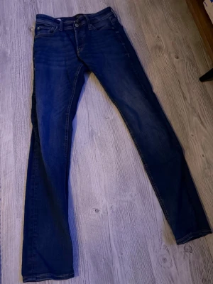 Mörkblå raka jeans med stretch - Snygga mörkblå jeans med raka ben och klassisk femficksdesign. Jeansen har en lätt tvättad look och är tillverkade i stretchigt denimtyg för extra komfort. Passar perfekt till en avslappnad stil.