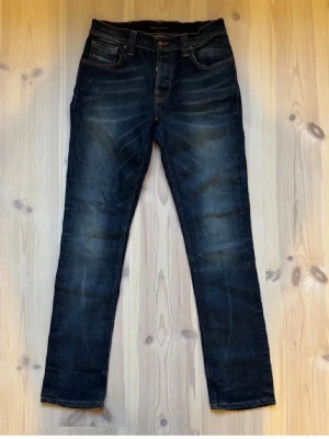 Nudie Grim Tim jeans  - Säljer ett par nudie jeans Grim Tim w30 L32 med en skön fade och bra material. Hör av dig vid frågor eller funderingar!