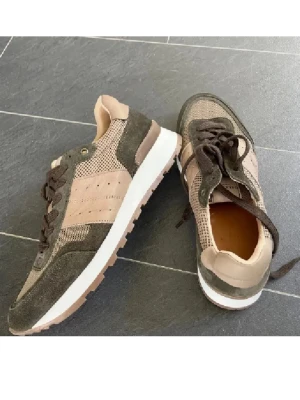 Beige och gröna sneakers Selected Homme - Snygga sneakers från Selected Homme i beige och grönt med mesh och mockadetaljer. Skorna har bruna snören, vit sula och diskret logga på plösen. Perfekt för dig som gillar en stilren och avslappnad look.