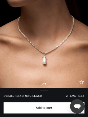 Silverhalsband med droppformad pärla - Elegant halsband i silver med en droppformad vit pärla som hänge. Kedjan är tunn och stilren, och pärlan ger ett klassiskt och lyxigt intryck. Perfekt för dig som gillar minimalistiska smycken med en twist.