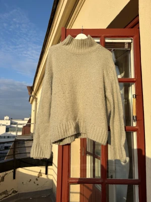 Ljusgrön stickad polotröja från H&M - Mysig ljusgrön stickad polotröja från H&M med avslappnad passform och ribbade muddar vid ärmslut och nederkant. Tröjan har hög krage 