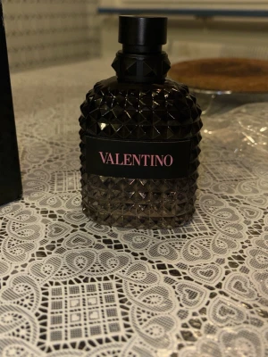 Valentino Uomo Born In Roma parfym - Säljer en Valentino Uomo Born In Roma parfym. Flaskan är svart med nitar och har en lyxig, modern design. Märket står tydligt på flaskan och förpackningen. Perfekt för dig som gillar exklusiva dofter och snygg inredningsdetalj på hyllan. Spreyat fåtal gånger och fick den som julklapp, men hade redan en identisk doft min kollektion 