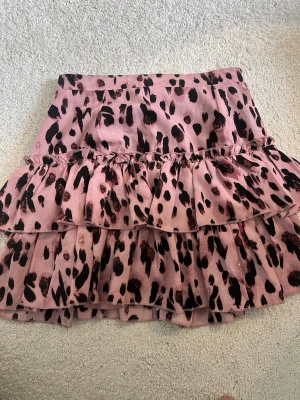 Rosa volangkjol med leopardmönster - En söt kort rosa kjol med volanger och leopardmönster. Dessvärre finns lappen inte kvar, men den uppskattade storleken är S🩷