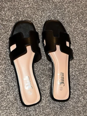 Svarta slip-in sandaler  - Säljer dessa sandaler då de ej passade i storlek när jag köpte, aldrig varit använda , strl 39