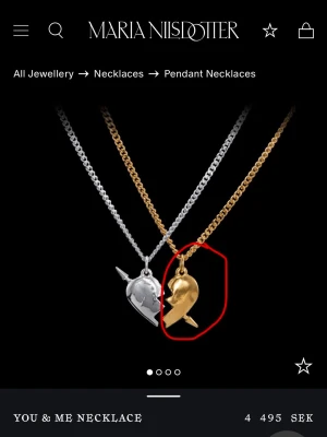 Guldigt halsband med delat hjärta - Halsband i guldfärgad metall med en halva av ett delat hjärta som hänge. Hjärtat har en pil genom sig.