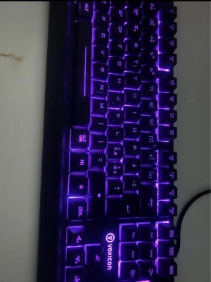 Voxicon tangentbord med RGB-belysning - Säljer ett Voxicon tangentbord med snygg RGB-belysning som kan växla mellan lila och andra 5 färger Tangentbordet har en klassisk svart design och är gjort i plast. Perfekt för gaming eller studier,