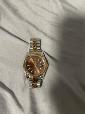 Två tonad date just klocka  - Klockan har box och tillbehör för mer bilder skriv till mig. De kan lysa i mörker och väger 195 gram. Går automatisk.