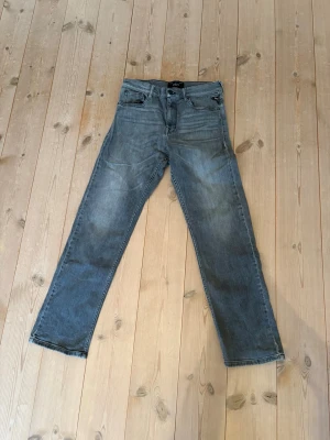 Gråa jeans från replay - Säljer ett par gråa jeans från replay i modellen Thad. Jeansen har inga hål eller fläckar men materialet är lite urtvättat vilket gör det lite slitet. Passformen är standard. Storleken är 14A vilket motsvarar storlek 158. Snabb affär= billigare 