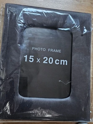Svart fotoram i sammet 15x20 cm - En stilren svart fotoram i storleken 15x20 cm. Ramen har en enkel och modern design och är tillverkad i ett material som ser ut som sammet eller mjuk textil. Perfekt för att visa upp dina favoritbilder.