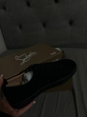 Svarta Louboutin sneakers med röd sula - Snygga svarta sneakers från Christian Louboutin. Har endast ett par först t kvarn dom lägg upp billigt.