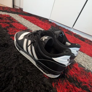 Svartvita Adidas sneakers - Klassiska Adidas sneakers i svart och vit. Jätte hållbara och bekväma, de är använda lite men ser väldubra ut. Det är inte sönder eller så. Nypris 1399 kr.