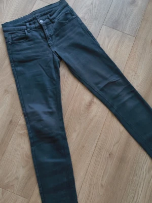 Vintage svarta slim jeans från Cheap Monday - Snyggt slitna svarta slim fit jeans från Cheap Monday med klassisk femficksdesign och logga på knappen. Jeansen har en smal passform och är tillverkade i ett stretchigt denimtyg som sitter bekvämt hela dagen.