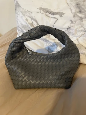 Grå flätad handväska  - Snygg grå fätad handväska 