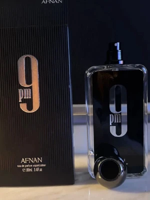Afnan 9PM Eau de Parfum 100ml svart och röda  - Afnan 9PM Eau de Parfum är en parfym i en stilren, rektangulär glasflaska det luktar så gott och bra finns röda oxå helt nya med paketet PRIS KAN DISKUTERAS!!!