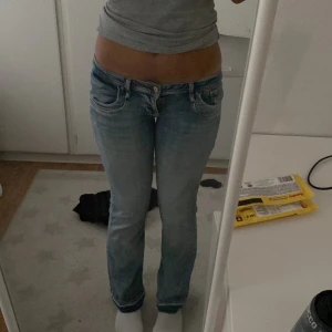 Ltb lågmidjade jeans  - Säljer ett par snygga ltb bootcut jeans i ljusblå tvätt med slitningar. Jeansen har låg midja, klassiska fem fickor och dragkedja. Perfekta för dig som gillar en avslappnad och trendig look. Säljer pågrund av för korta! Har även sprätt upp dom🩵