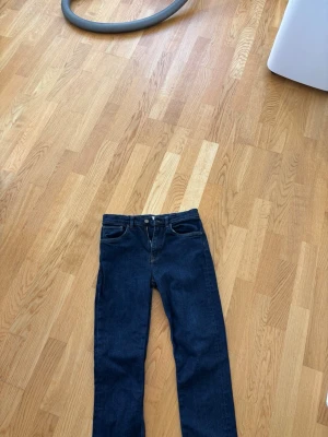 Mörkblå raka jeans från GANT - Snygga mörkblå jeans från GANT med klassisk rak passform och 4 fickor. Nypris 900kr Jeansen har en tidlös look med knapp- och dragkedjegylf samt kontrastsömmar. Perfekta för en clean och stilren outfit.