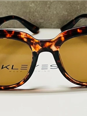 Bruna solglasögon från Kley - Snygga solglasögon från Kley med brunmelerat, leopardmönstrat båge och bruna glas. Klassisk rundad form som ger en cool vibe. Perfekta för soliga dagar och en trendig look. Änvand fåtal gånger 