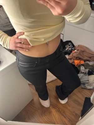 Svarta bootcut skinnjeans med låg midja - Säljer ett par svarta bootcut  jeans med låg midja och klassisk femficksdesign. Jeansen har en tight passform och är tillverkade i ett stretchigt material. Modell Low boot