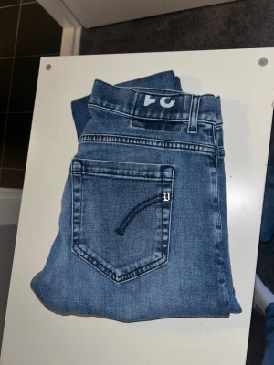 Blå raka jeans från dondup  - Säljer ett par klassiska blå jeans med rak passform och snyggt tvättad finish. Jeansen har fem fickor, bälteshällor och knappgylf. Perfekta för en avslappnad stil och passar till det mesta. Materialet är slitstark denim i bomull.