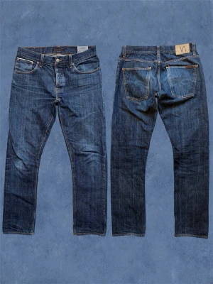 GRIM TIM *DRY OPEN SELVAGE* - Ett par helt sjuka nudie jeans i den populära slim/straight passformen ”Grim Tim”! Redan börjat fadea lite men mer kommer med användningen! Storlek 34/34 men utgå alltid ifrån måtten! Hör av dig vid frågor! Mått: Midja, 43 - Ytterben, 104 - Benslut, 19