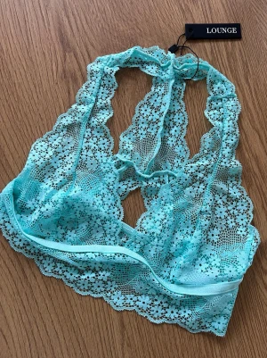 Lounge topp - Säljer en ny turkos topp från Lounge Underwear. Toppen är ärmlös och har vackra blommiga spetsdetaljer samt elastiskt band under bysten. Modell Floral Lace Triangle Bralette. Storlek S 🩵