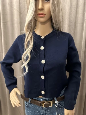 Mörkblå kofta med dekorativa knappar Xs-S - Snygg mörkblå kofta med rund halsringning och långa ärmar. Koftan har dekorativa silvriga knappar framtill som ger en elegant touch. Perfekt att bära öppen eller stängd för olika stilar. Materialet är mjukt och bekvämt.