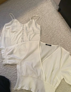 Klädpaket vit blus och vitt linne  - Super fin blus och ett vitt linne🌸  Båda är Från ginatricot  Blusen är i Storlek 38 och linnet i storlek S. Men Linnet är stort i storleken så mer en M❗️ ❗️Linnet har en liten fläck framtill-se bild… Super fina båda två✨ Perfekt till släktkalas, skola eller bara till vardags🌸   ✨Kolla gärna in mina andra annonser- finns bundle rabatt✨