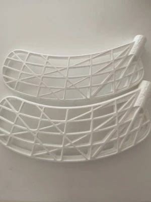 Vita innebandyblad från Unihoc  - Två vita innebandyblad från Unihoc med öppen, gallerliknande design. Bladen är tillverkade i plast och har en modern, lätt konstruktion som passar för snabba spel och bra bollkontroll. Bladet är evolite